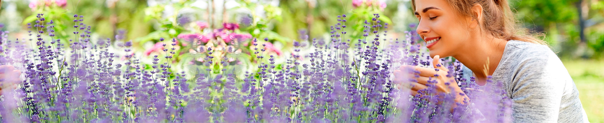 Een vrouw ruikt aan tuinplanten